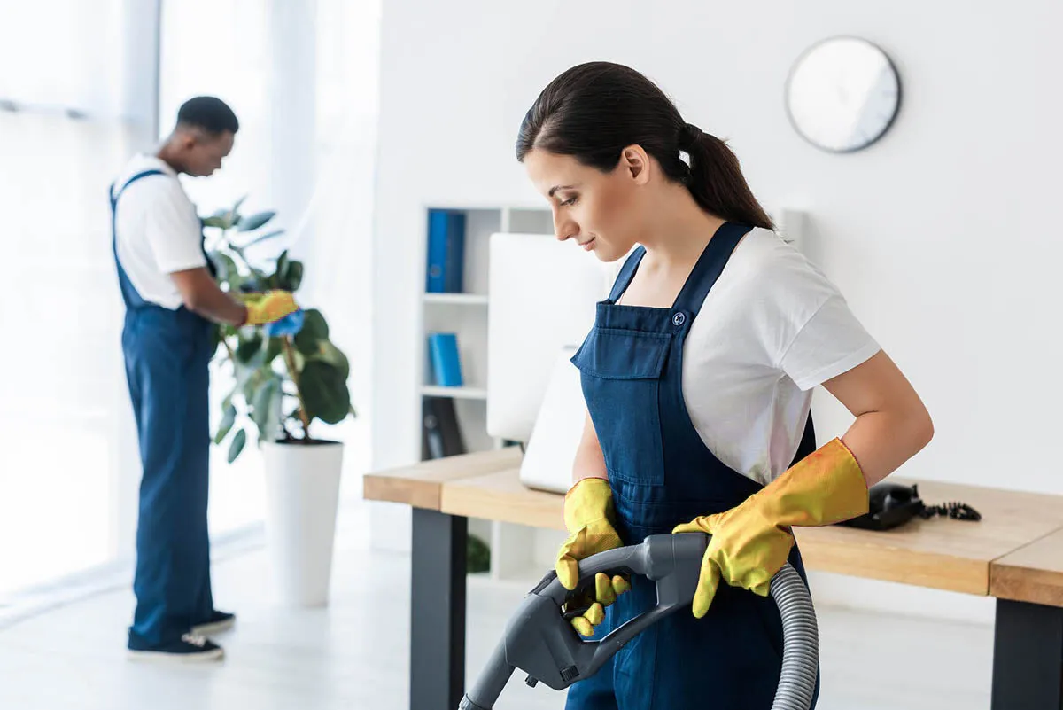 A cleaning technician vacuuming a home