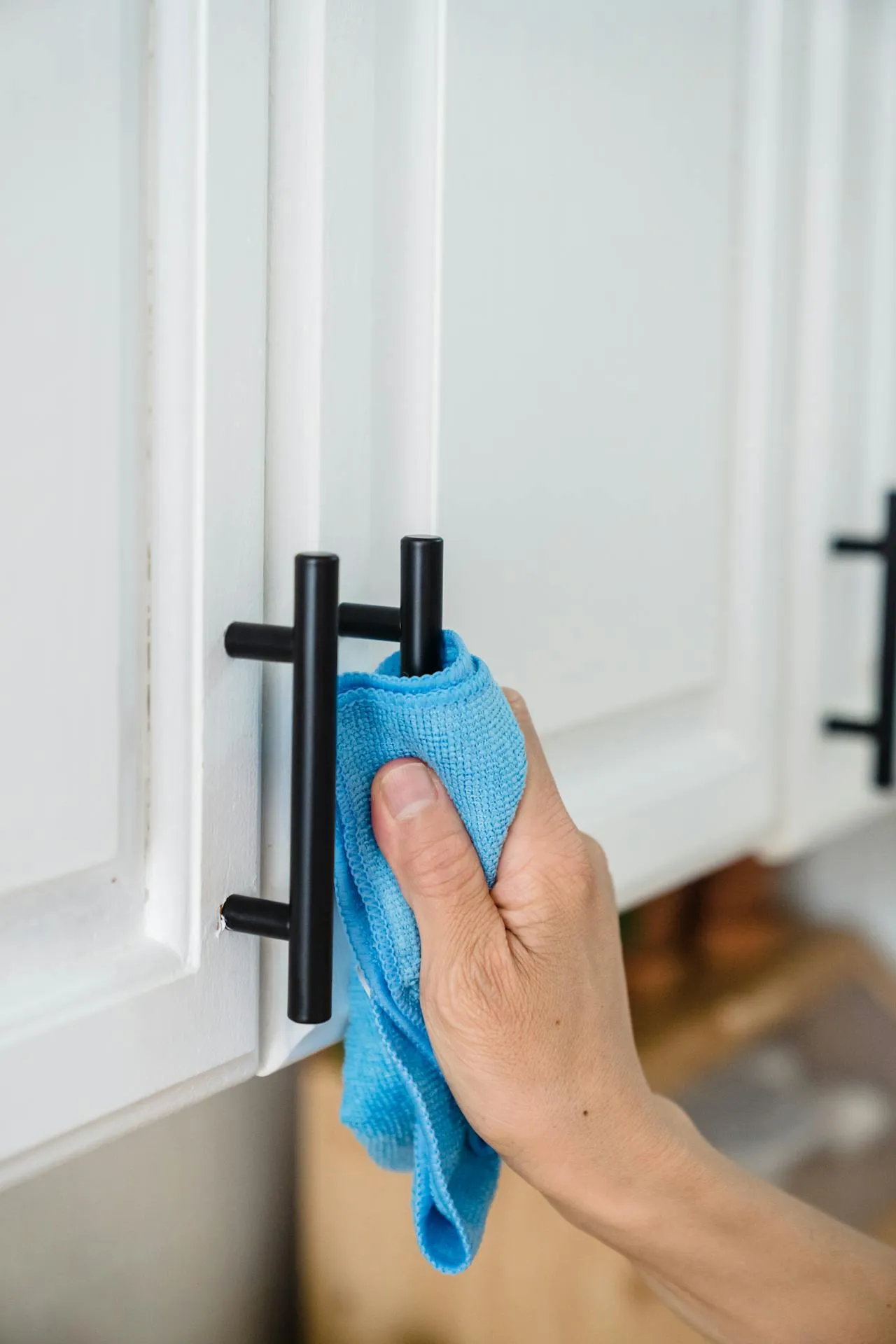 A cleaner wiping down a surface with a cloth